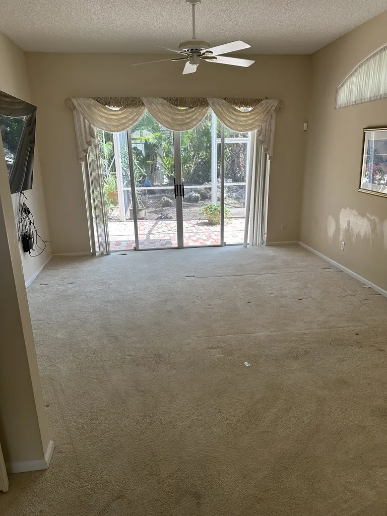Bedroom with light walls and carpet before painting and flooring work