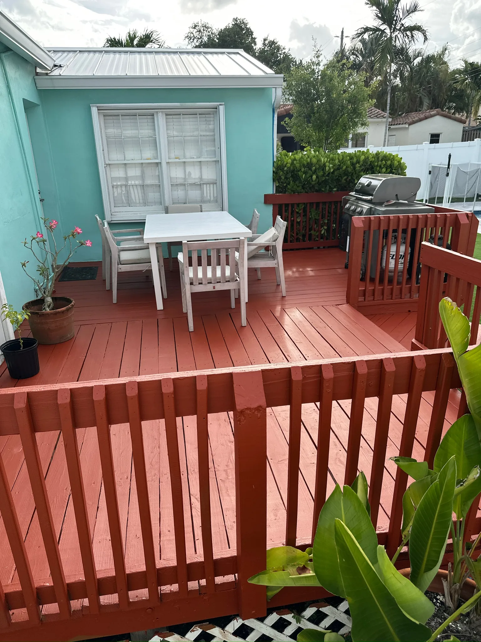 Backyard deck after repair preparation and warm red-orange repainting