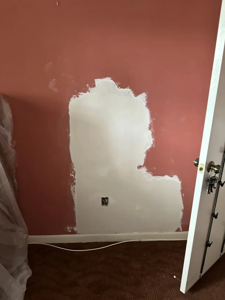 Joint compound applied and feathered over the repaired wall area