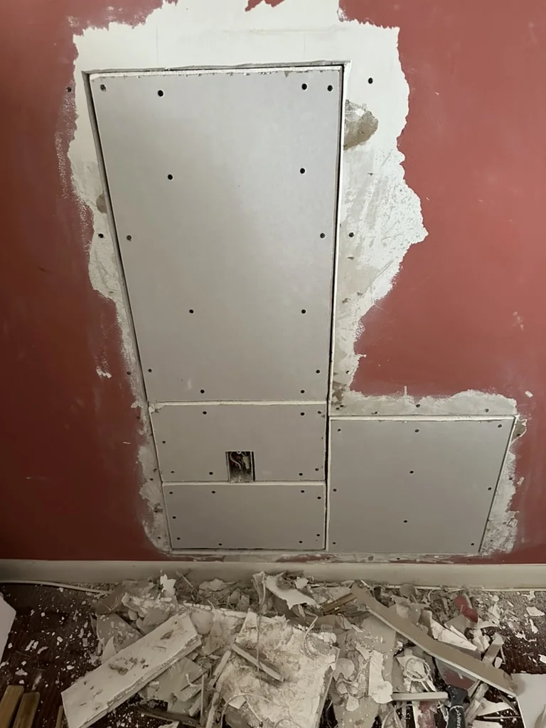 Fitted drywall patch panels installed over the existing wall opening