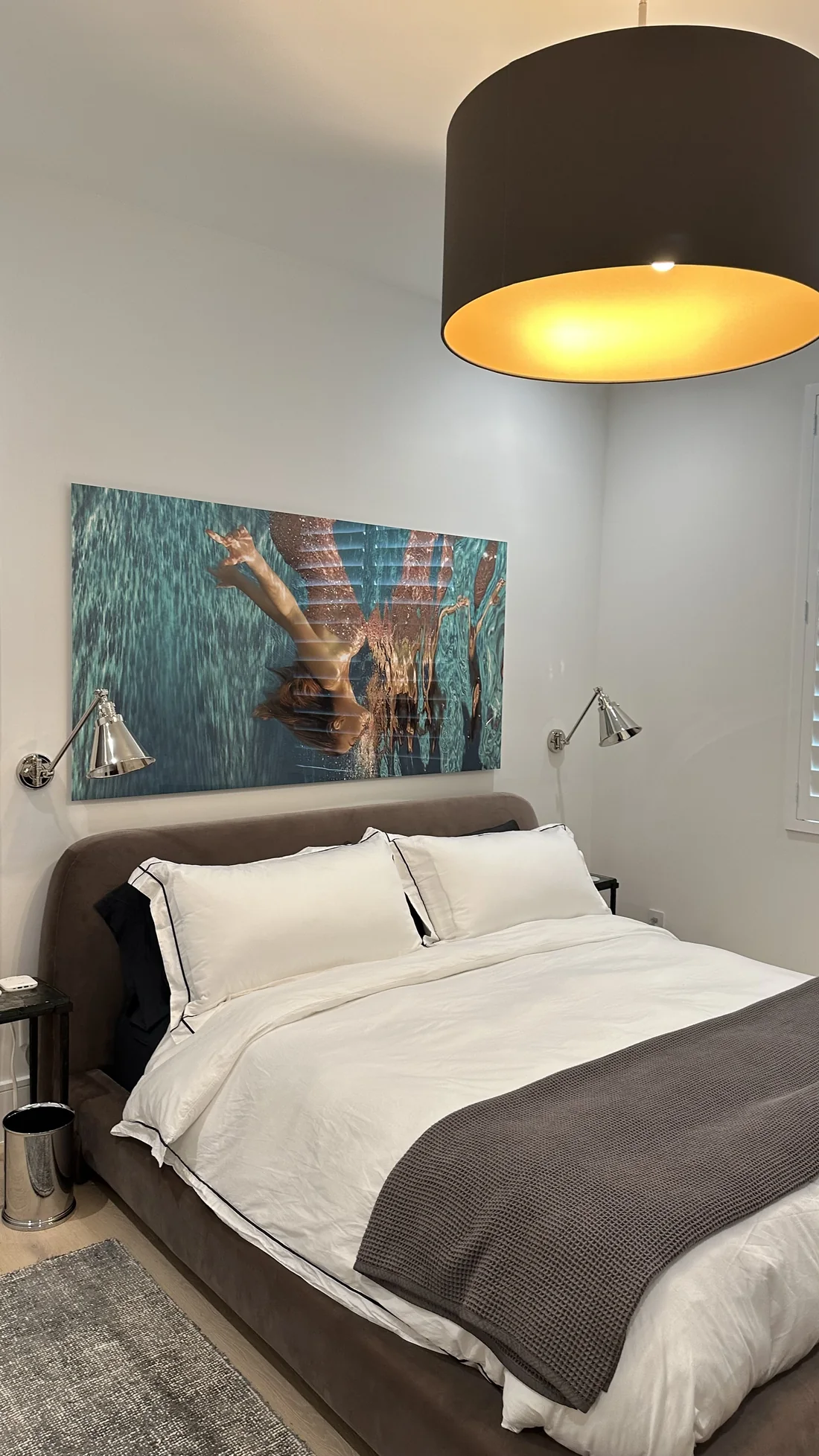 Finished bedroom with mounted artwork, installed furniture, and wall lights
