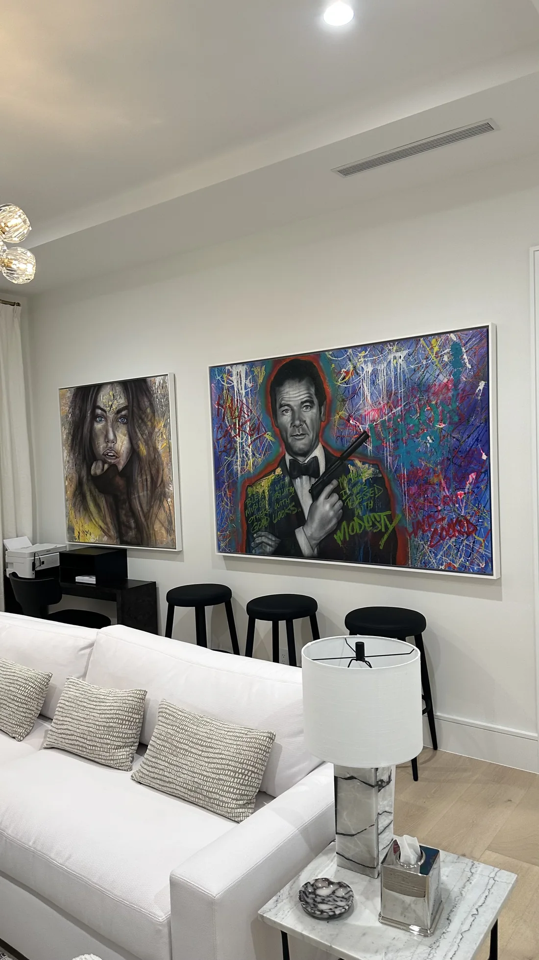 Living room with two large mounted artworks and installed curtains