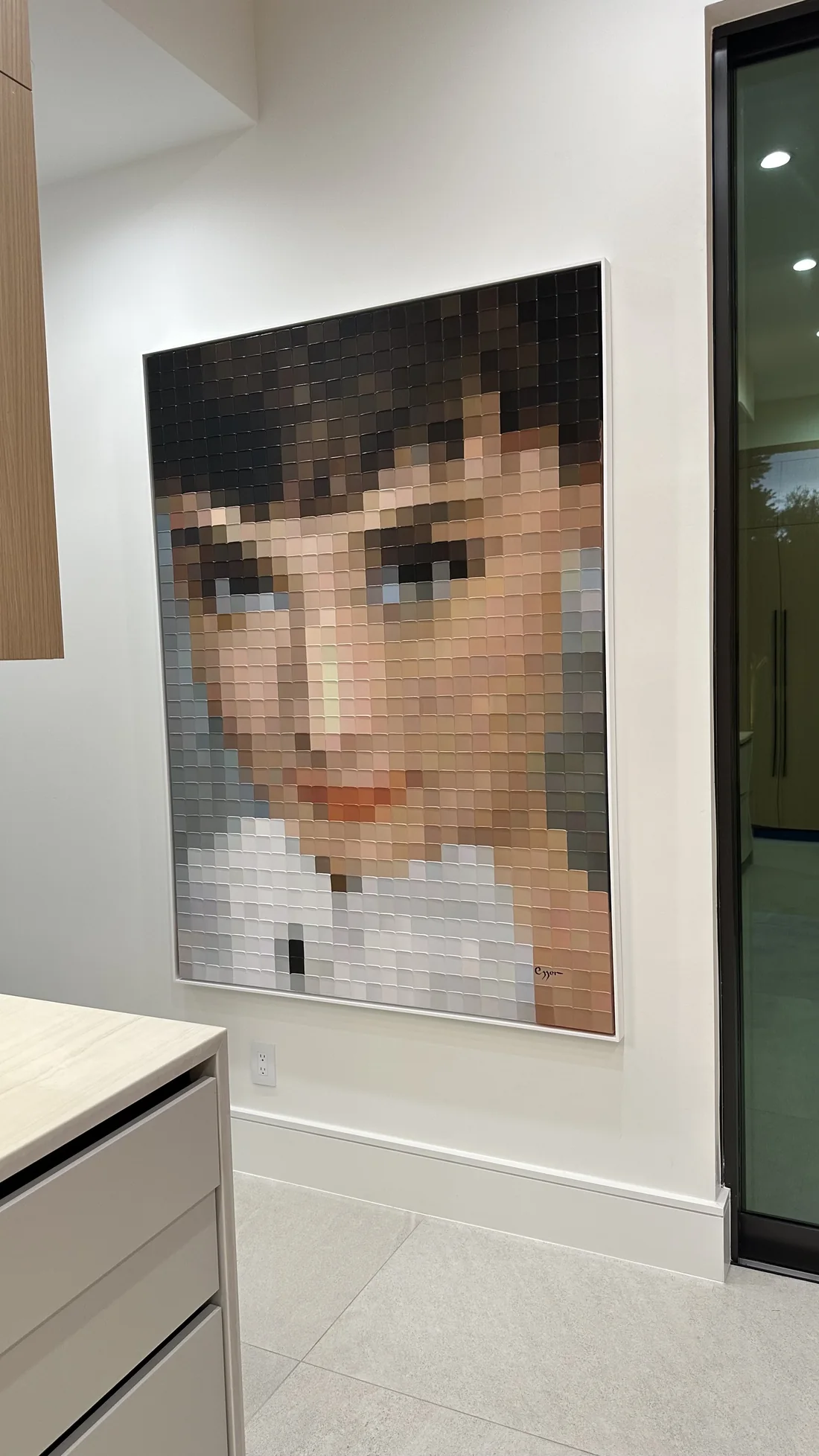 Large portrait artwork mounted on a high painted wall