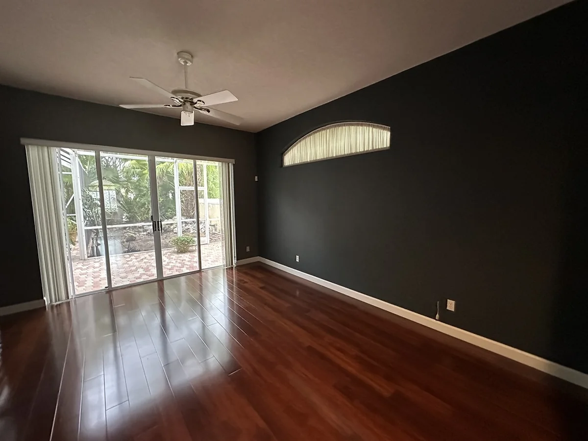 Bedroom with charcoal painted walls and warm plank flooring