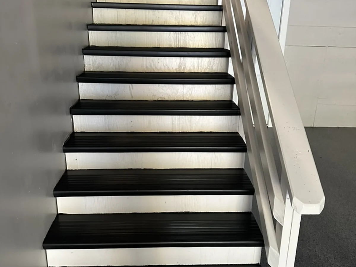 Black ribbed stair tread covers fitted over stairs with white risers