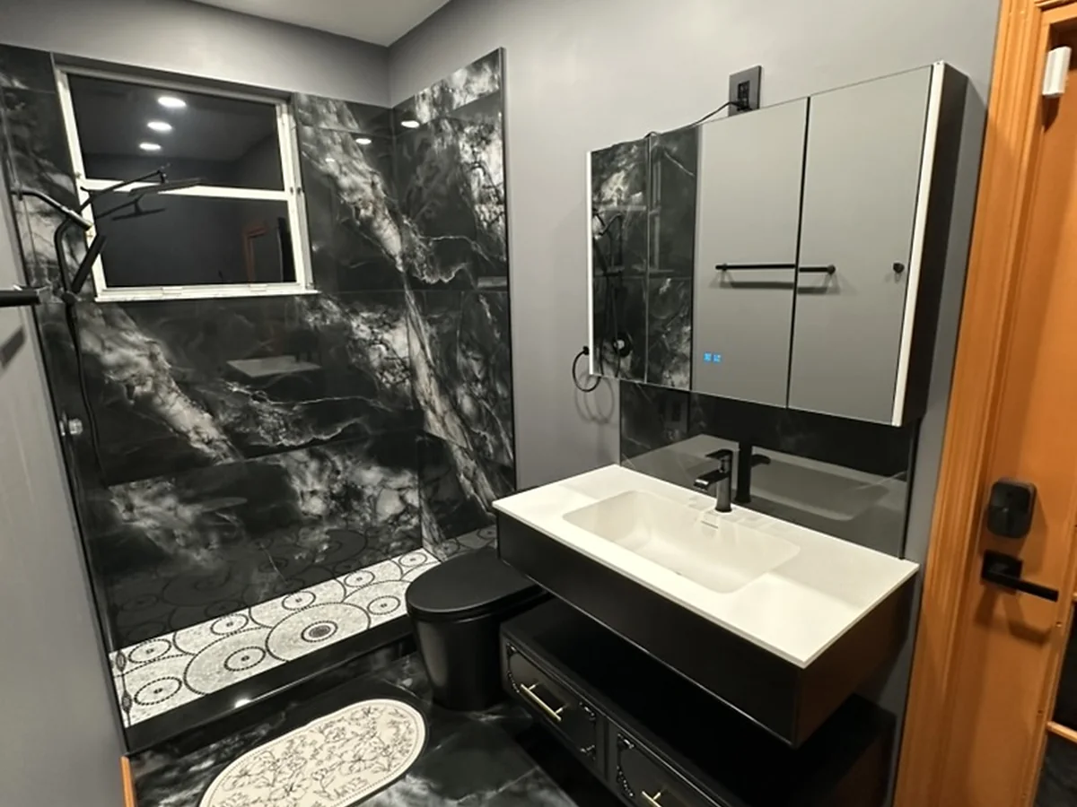 Bathroom with dramatic large-format wall tile and patterned shower floor