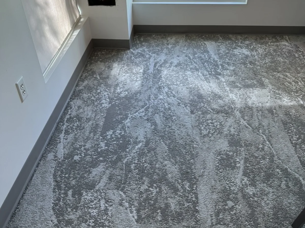 Gray patterned modular carpet tile floor with fitted edge transitions